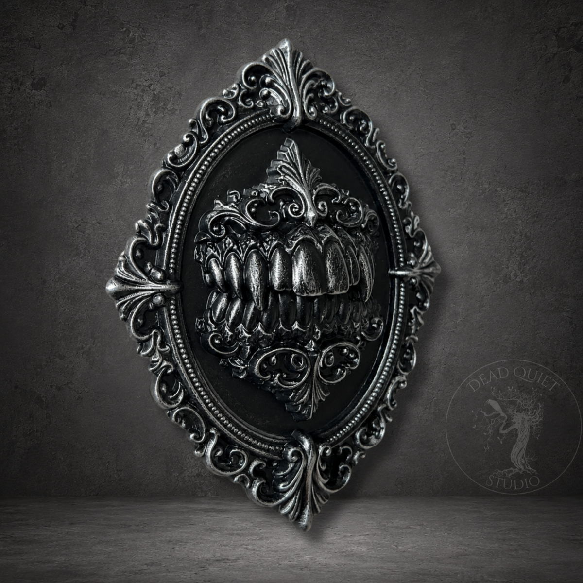 Close up of The Maw brooch showing sculpted monster teeth and silver detailing